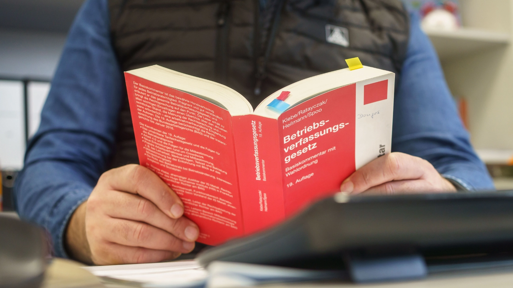 Betriebsrat Ercan Kaya liest im Betriebsverfassungsgesetz bei Donges in Darmstadt