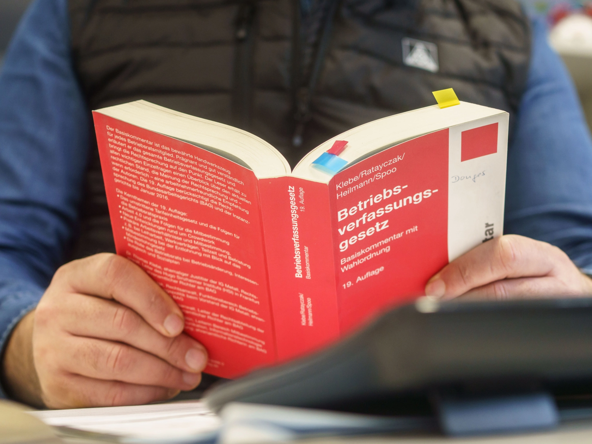 Betriebsrat Ercan Kaya liest im Betriebsverfassungsgesetz bei Donges in Darmstadt